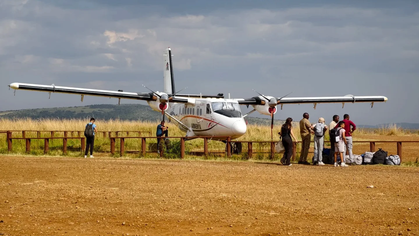 Small safari aircraft waiting with passengers at a bush airstrip in Kenya