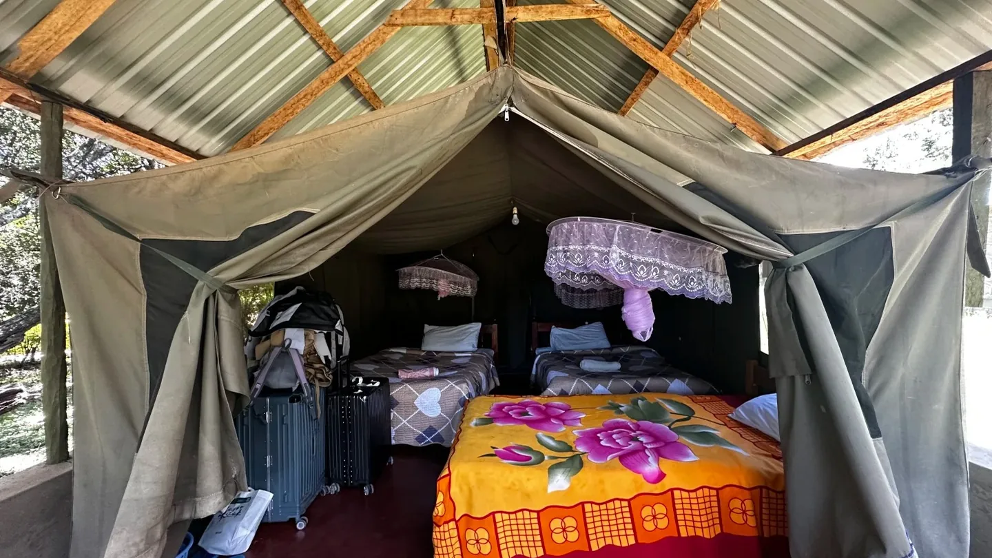 Simple canvas bedroom inside a budget tented camp in the Maasai Mara