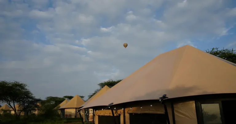 Canvas suites at Malaika Luxury Camp in Ndutu with a hot-air balloon in the sky