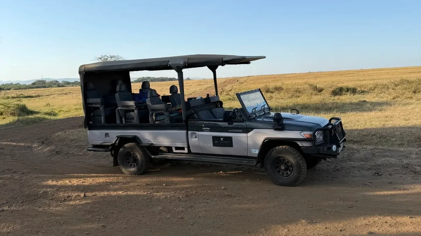 Open-sided safari vehicle parked on open grassland